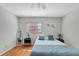 Light-filled bedroom boasts hardwood floors, a ceiling fan, two windows for ample sunlight, and neutral walls at 9503 Alice Ln, Riverview, FL 33578