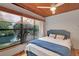 Bedroom featuring wood ceiling, fan, and a large window with a view of the water and lush greenery at 9503 Alice Ln, Riverview, FL 33578