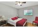 Bright bedroom with hardwood floors, a ceiling fan, natural light, and warm red accents at 9503 Alice Ln, Riverview, FL 33578