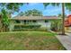 Charming single-story home featuring lush landscaping and a welcoming front porch in a serene setting at 9503 Alice Ln, Riverview, FL 33578