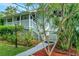 Inviting front porch with white railing and steps, surrounded by mature landscaping at 9503 Alice Ln, Riverview, FL 33578