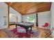 Spacious game room featuring a pool table, wood-paneled ceiling, hardwood floors, and bright natural light at 9503 Alice Ln, Riverview, FL 33578