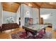 Large game room with a pool table, hardwood floors, wood panel ceiling, and an adjacent seating area at 9503 Alice Ln, Riverview, FL 33578