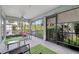 Enclosed screened patio boasts outdoor seating, a fan, and views of tropical landscaping at 9503 Alice Ln, Riverview, FL 33578