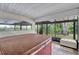 Enclosed patio featuring a hot tub, outdoor seating, and views of lush landscaping at 9503 Alice Ln, Riverview, FL 33578
