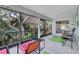 Enclosed patio featuring screened windows, outdoor seating, and views of lush landscaping at 9503 Alice Ln, Riverview, FL 33578