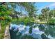 Scenic waterfront with a calm canal reflecting the blue sky and lush vegetation at 9503 Alice Ln, Riverview, FL 33578