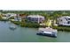 Aerial view of an exclusive waterfront property, featuring a covered dock, lush greenery, and a luxurious home at 112 Osprey Point Dr, Osprey, FL 34229