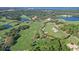 Expansive aerial view of a golf course community featuring lush landscaping, multiple greens, and a central clubhouse at 112 Osprey Point Dr, Osprey, FL 34229