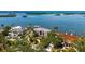 Aerial view of an elegant waterfront home with mature landscaping and a private boat dock at 112 Osprey Point Dr, Osprey, FL 34229