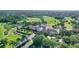 Overhead view of a manicured golf course and luxurious clubhouse with a red tile roof at 112 Osprey Point Dr, Osprey, FL 34229