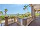 Charming waterfront balcony view showcasing the serene waterfront scenery with tropical palm trees on a clear, sunny day at 112 Osprey Point Dr, Osprey, FL 34229