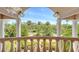 Inviting balcony view with white pillars overlooks lush landscaping, blue skies, and mature tropical trees at 112 Osprey Point Dr, Osprey, FL 34229
