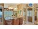 Bathroom with a dark wood vanity, granite countertop, and mirrored walls around the large soaking tub at 112 Osprey Point Dr, Osprey, FL 34229