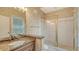 Bathroom featuring a granite countertop, decorative wallpaper, and a glass shower at 112 Osprey Point Dr, Osprey, FL 34229