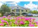 Charming clubhouse with vibrant flower beds, lush greenery, and ample parking, creating an inviting community atmosphere at 112 Osprey Point Dr, Osprey, FL 34229