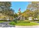 Elegant community entrance featuring manicured landscaping, American flag, and decorative gatehouses at 112 Osprey Point Dr, Osprey, FL 34229
