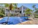 Stunning exterior view of a spacious waterfront home featuring an in-ground pool and lush tropical landscaping at 112 Osprey Point Dr, Osprey, FL 34229