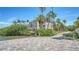 Expansive exterior view of a waterfront home with lush landscaping and private access to the open water at 112 Osprey Point Dr, Osprey, FL 34229
