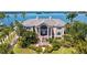 Stunning waterfront home with lush landscaping, beautiful water views, and a grand, columned entrance at 112 Osprey Point Dr, Osprey, FL 34229