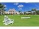 Scenic view of a meticulously maintained golf course and clubhouse with Adirondack chairs at 112 Osprey Point Dr, Osprey, FL 34229