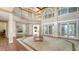 Expansive living room with soaring ceilings, clerestory windows, and lake view beyond the lanai at 112 Osprey Point Dr, Osprey, FL 34229