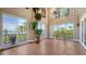 Bright living room with tile flooring, multiple sliding glass doors, and views of tropical landscaping at 112 Osprey Point Dr, Osprey, FL 34229