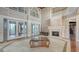 Spacious living room featuring tall ceilings, stone fireplace, French doors, and bright, sunny windows at 112 Osprey Point Dr, Osprey, FL 34229