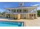 Stunning pool house featuring a two-story design, open balconies, and charming architectural details near pool at 112 Osprey Point Dr, Osprey, FL 34229