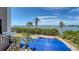 Aerial view from the balcony of a large swimming pool with a full cover with waterfront views on a sunny day at 112 Osprey Point Dr, Osprey, FL 34229