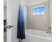 This bathroom has a shower/tub combo with a curtain and a small window at 2943 Willowleaf Ln, Wesley Chapel, FL 33544
