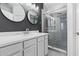 This bathroom features a white vanity with a gray countertop and a tiled shower behind glass at 2943 Willowleaf Ln, Wesley Chapel, FL 33544