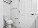 This bathroom has white walls, gray tile flooring, a toilet, and a storage closet at 2943 Willowleaf Ln, Wesley Chapel, FL 33544