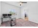This room has a window, ceiling fan, and a desk with two monitors at 2943 Willowleaf Ln, Wesley Chapel, FL 33544