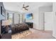 This bedroom features a ceiling fan, ensuite bathroom, and plush carpeting at 2943 Willowleaf Ln, Wesley Chapel, FL 33544