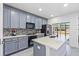 Modern kitchen with gray cabinets, stainless steel appliances, and a spacious island at 2943 Willowleaf Ln, Wesley Chapel, FL 33544