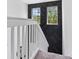 Staircase with black accent wall and wall art near two windows, complemented by white railing and neutral carpeting at 2943 Willowleaf Ln, Wesley Chapel, FL 33544
