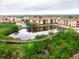 Aerial view of the buildings with serene pond and lush landscape and wooden walkway at 4333 Bayside Village Dr # 310, Tampa, FL 33615