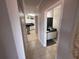 Hallway leads to a white kitchen and a bathroom with a black countertop and white cabinets at 4333 Bayside Village Dr # 310, Tampa, FL 33615