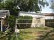 Spacious backyard with lawn, volleyball net, storage unit, and wooden privacy fence at 7026 Lenape Cir, New Port Richey, FL 34653