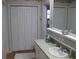 Neutral bathroom featuring a vanity, mirror, white cabinets and bi-fold door for closet at 7026 Lenape Cir, New Port Richey, FL 34653