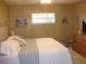 Comfortable bedroom with queen bed, wooden dresser and a window at 7026 Lenape Cir, New Port Richey, FL 34653