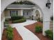 Inviting home entrance with decorative brick archway, landscaping, and double front doors at 7026 Lenape Cir, New Port Richey, FL 34653