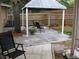 Backyard patio features a gazebo with chairs, along with mulched flowerbeds and trees at 7026 Lenape Cir, New Port Richey, FL 34653