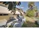 The backyard features a patio seating area shaded by awnings and tropical foliage, perfect for enjoying outdoor living at 7418 Riverbank Dr, New Port Richey, FL 34655