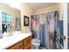 Bright bathroom with marble-themed shower curtain and wooden vanity at 7418 Riverbank Dr, New Port Richey, FL 34655