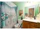 Bright bathroom with floral shower curtain and wooden vanity at 7418 Riverbank Dr, New Port Richey, FL 34655