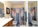 Bright bathroom with neutral shower curtain and dark wood vanity at 7418 Riverbank Dr, New Port Richey, FL 34655