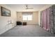 Bright bedroom featuring a large window with floral valance and curtains, plus neutral wall color at 7418 Riverbank Dr, New Port Richey, FL 34655