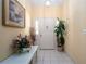 Bright entryway showcasing tiled floor, decorative artwork, and an elegant floral arrangement at 7418 Riverbank Dr, New Port Richey, FL 34655
